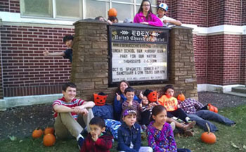 Young people with their candy buckets gathered around Eden's sign'